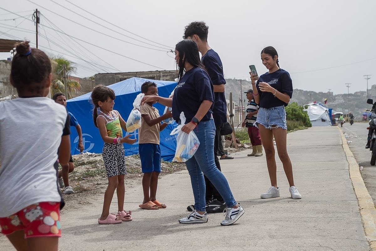 Volunteer handing supplies to a family